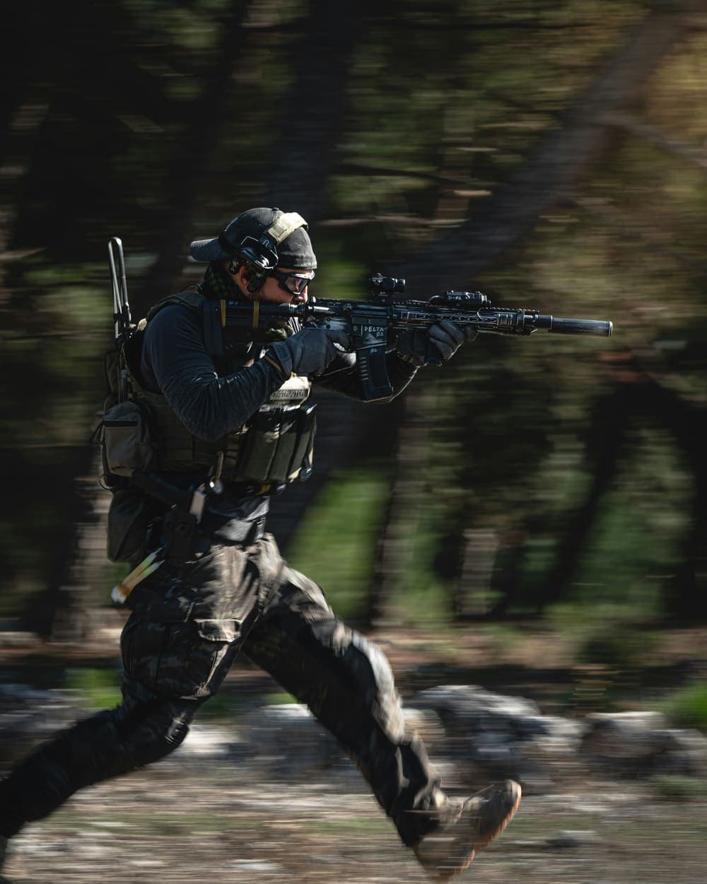 A shooter moving at speed on a wooded range